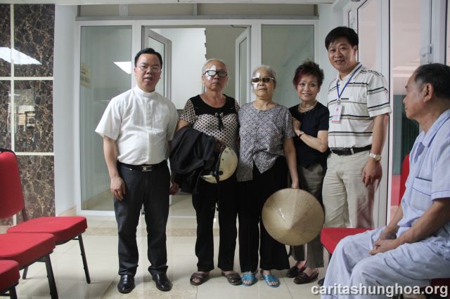 Cha Giuse Nguyễn Văn Thành và Cha Phaolô Nguyễn Quốc Anh chụp hình cùng các bệnh nhân sau khi được phẫu thuật